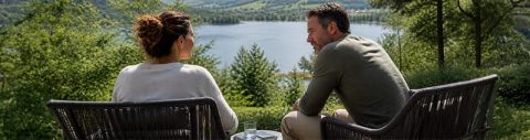 Executive Leadership Coaching für C-Level: Frau und Mann unterhalten sich in persönlicher Atmosphäre mit Weitblick auf einen See
